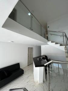 Habitación blanca con escalera y mesa negra en Hotel Lago Boutique, en Cartagena de Indias