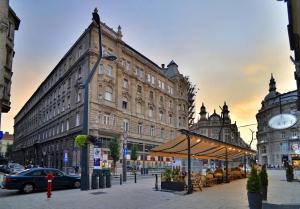 eine Stadtstraße mit Gebäuden und einem Uhrturm in der Unterkunft Focus Point Apartments in Budapest