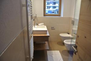 een badkamer met een wastafel en een toilet bij Chalet Prades Dolomiti Lodges in La Villa +17 foto's