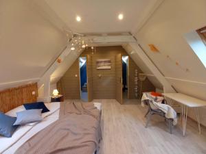 a bedroom with a large bed in a attic at chambres d'hôtes Au Gré du Vent en Normandie in Malleville-les-Grès