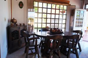 uma cozinha com uma mesa com cadeiras e uma taça de fruta em Casa Campestre El Rosal em Santana
