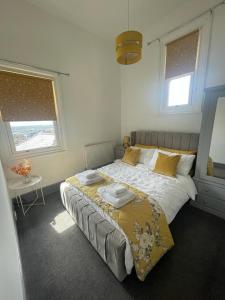 a bedroom with a bed and a table and two windows at Castle Mount in Lincoln