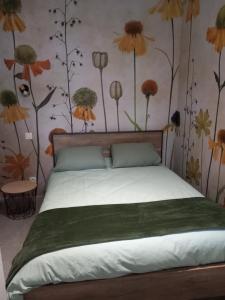a bedroom with a bed with flowers on the wall at La cour fleurie, tout confort in Dijon