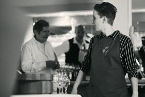 Ein Mann, der an einem Tresen in einer Bar steht. in der Unterkunft Hotel Restaurant Luise in Badenweiler