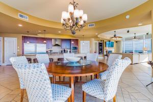 cocina y comedor con mesa de madera y sillas en Turquoise Place 809D, en Orange Beach