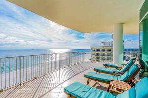 un balcón con tumbonas azules y el océano en Turquoise Place 809D, en Orange Beach