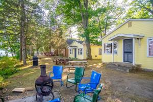 a yard with chairs and a table and a building at Smith Family Cottages- Cottage #1 in Indian River