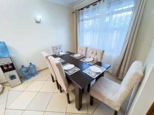 a dining room with a table and chairs and a window at Majestic Homes in Nyali