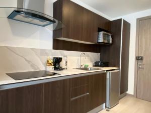 a kitchen with wooden cabinets and a sink at Gold & Black, Premiere Suite and Pool, Sector Carolina in Quito
