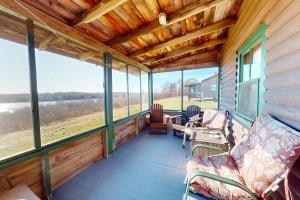 a screened in porch with chairs and windows at Castine Cottages #6 in Castine