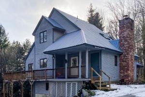 a gray house with a porch and a chimney at A Very Vermont Vacation in Jamaica