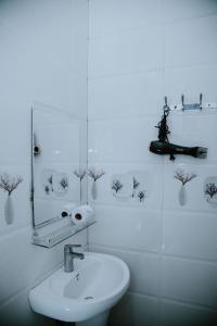 Baño blanco con lavabo y espejo en Zanzibar Spice Hut Apartment en Stone Town