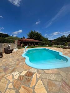 una gran piscina en un patio con un balcón azul en Refúgio da Mantiqueira en Passa Quatro