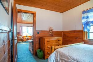 um quarto com uma cama, uma cómoda e uma janela em Smith Family Cottages - Cottage #3 em Indian River