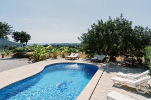 uma piscina com cadeiras e cadeiras ao lado em Can Pep Gibert em Ibiza