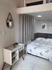 Schlafzimmer mit einem Bett, einer Kommode und einem Spiegel in der Unterkunft Casa do Henrique 3 in Sorocaba