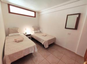 a small room with two beds and a mirror at Tenerife Flamingo in Palm-mar