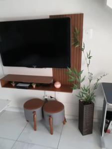 ein Wohnzimmer mit einem Flachbild-TV an der Wand in der Unterkunft Casa do Henrique 3 in Sorocaba
