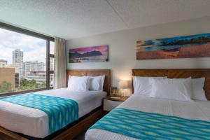 Cette chambre comprend 2 lits et une fenêtre. dans l'établissement Waikiki Banyan Ohana Suite, à Honolulu
