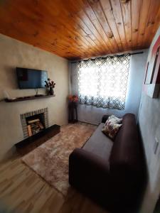 - un salon avec un canapé et une cheminée dans l'établissement Sítio jaguary, à Camanducaia