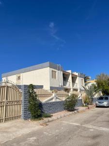 Una casa con una valla y un coche aparcado delante. en Villa Touristic Village Nr 7030, en Hurghada