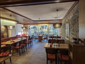 a dining room with tables and chairs and windows at Hotel und Weingut Karlsmühle in Mertesdorf