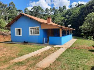 a blue house in the middle of a yard at Sítio jaguary in Camanducaia