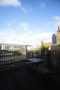 a picnic table on a balcony with a fence at Very Nice Flat close to Camden Station in London