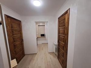 an empty room with two doors and wooden floors at At Starunchakiv family in Yaremche