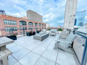 a balcony with chairs and tables on a building at McCormick 2br/2ba Oasis with Optional Parking, Patio, Gym for up to 6 guests in Chicago