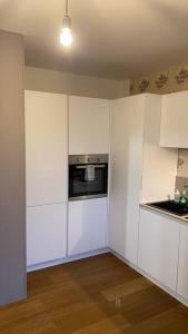 an empty kitchen with white cabinets and an oven at Appartamento Nord Udine in Feletto Umberto