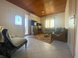 a living room with two chairs and a door at Μονοκατοικια 3 δωματιων in Katerini