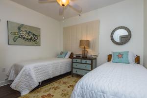 a bedroom with two beds and a mirror at Beach Club - Doral 1503 - DIRECT BEACHFRONT, INCREDIBLE VIEWS, COZY DECOR, TONS OF AMENITIES! in Gulf Highlands +49 photos