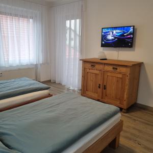 a bedroom with two beds and a flat screen tv at Ferienwohnung am Enzufer mit Balkon in Bad Wildbad im Schwarzwald in Bad Wildbad