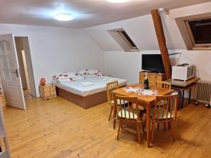 ein kleines Zimmer mit einem Bett, einem Tisch und einem Tisch in der Unterkunft Podkroví v Jihočeském Statku in Nemějice