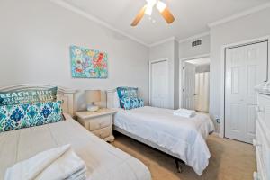 a bedroom with two beds and a ceiling fan at Beach Club Avalon 1204 in Gulf Highlands +54 photos