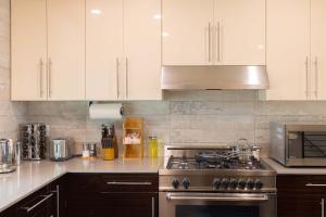 a kitchen with white cabinets and a stove top oven at 47th Elegance BY Betterstay in Seattle