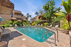 una piscina con sillas y un edificio en Kamaole Beach Club B107 BY Betterstay, en Kihei