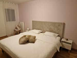 a bedroom with a white bed with two stuffed animals on it at Résidence neuve avec parking intérieur et balcon in Vienne