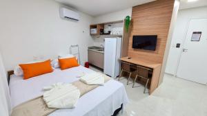 a bedroom with a bed with orange pillows and a desk at Sunset by AFT - PORTO DE GALINHAS in Porto De Galinhas