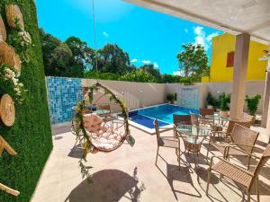a patio with a table and chairs and a swimming pool at Sunset by AFT - PORTO DE GALINHAS in Porto De Galinhas +28 photos