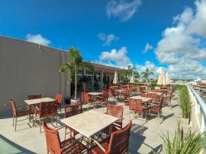 an outdoor patio with tables and chairs and umbrellas at Sunset by AFT - PORTO DE GALINHAS in Porto De Galinhas