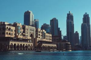 a building in front of a city with tall buildings at UAE Capsule Hostel 5 min Walkable from Sharaf DG Metro in Dubai