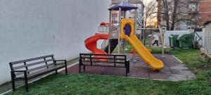 un parque infantil con un tobogán y dos bancos en Finans1, en Ruma