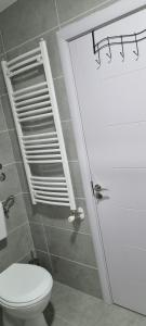 Un baño con un inodoro blanco y un espejo. en Finans1, en Ruma 16 fotos más