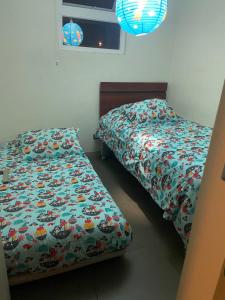 dos camas sentadas una al lado de la otra en un dormitorio en apartamento, en La Serena