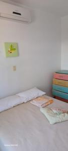 een slaapkamer met een bed met witte lakens en een dressoir bij Duplex na Praia dos Ingleses in Florianópolis