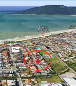 een kaart van een strand met een rode cirkel bij Duplex na Praia dos Ingleses in Florianópolis