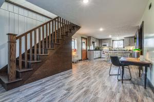 a living room with a staircase and a kitchen at Serene Tell City Retreat Near Hiking and Skiing! in Tell City