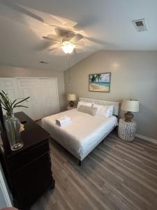 a bedroom with a white bed and a ceiling fan at Suite Carolina in Charleston